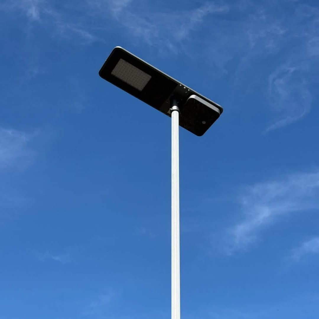 Lanterne solaire intégrée en haut d'un mât blanc